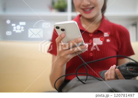 Cheerful young woman checking notifications and messages on smartphone 120781497