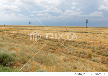 Vast Kazakh Steppe Landscape with Power Lines Beneath Dramatic Sky Vast Kazakh Steppe Landscape with Power Lines Beneath Dramatic Sky 120782594