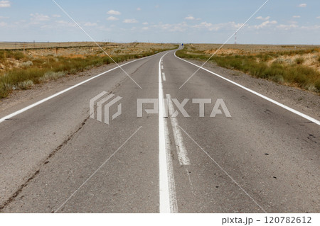 Expansive highway stretching through the scenic landscape of Kazakhstan under a clear sky 120782612