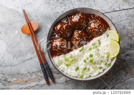 Glazed meatballs in honey sriracha sauce served with rice close-up in a bowl. horizontal top view 120782660