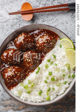 Asian Honey Sriracha Meatballs with rice closeup on the bowl. Vertical top view Asian Honey Sriracha Meatballs with rice closeup on the bowl. Vertical top view 120782664