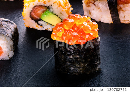 Sushi rolls on a black background. Ikura maki roll and others on black Sushi rolls on a black background. Ikura maki roll and others on black 120782751