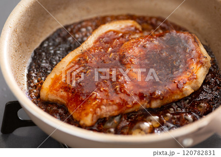 フライパンで豚の肩ロースの照り焼きポークステーキ(ポークジンジャー)を焼く フライパンで豚の肩ロースの照り焼きポークステーキ(ポークジンジャー)を焼く 120782831