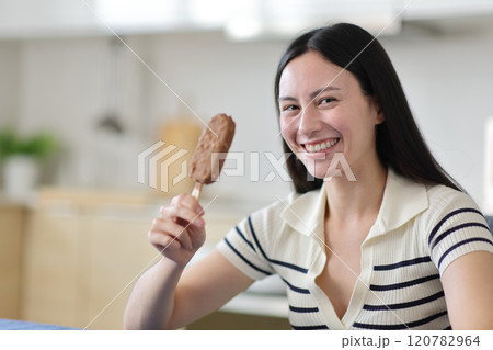 Happy asian woman holding chocolate ice cream looking at you Happy asian woman holding chocolate ice cream looking at you 120782964