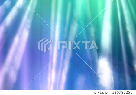 Blurred rays of light from stage spotlights on a purple-green background. 120783256