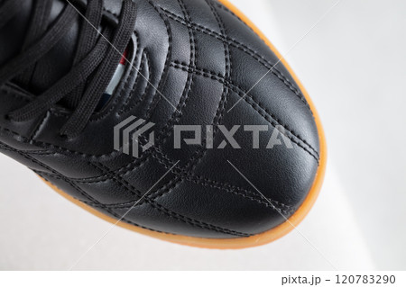 Part of a black leather sneaker with stitching close-up. Part of a black leather sneaker with stitching close-up. 120783290