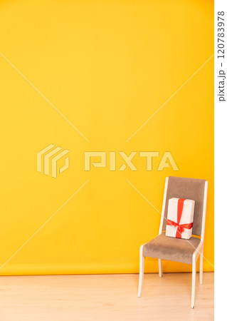 gift on a chair in the interior of a yellow orange living room 120783978