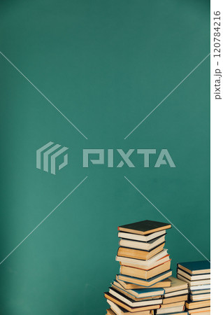 Stacks of books for reading and education in college library on green background Stacks of books for reading and education in college library on green background 120784216