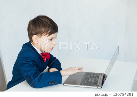 Boy In Business Suit Studying Playing On Laptop Online Boy In Business Suit Studying Playing On Laptop Online 120784291
