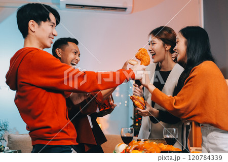 Group of young Asian man and women as friends having fun at a New Year's celebration, holding gift boxes standing by Christmas tree decoration, midnight countdown Party at home with holiday season. Group of young Asian man and women as friends having fun at a New Year's celebration, holding gift boxes standing by Christmas tree decoration, midnight countdown Party at home with holiday season. 120784339