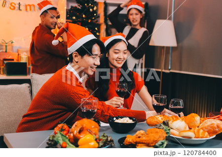 Group of young Asian man and women as friends having fun at a New Year's celebration, holding gift boxes standing by Christmas tree decoration, midnight countdown Party at home with holiday season. Group of young Asian man and women as friends having fun at a New Year's celebration, holding gift boxes standing by Christmas tree decoration, midnight countdown Party at home with holiday season. 120784400