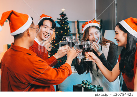 Group of young Asian man and women as friends having fun at a New Year's celebration, holding gift boxes standing by Christmas tree decoration, midnight countdown Party at home with holiday season. Group of young Asian man and women as friends having fun at a New Year's celebration, holding gift boxes standing by Christmas tree decoration, midnight countdown Party at home with holiday season. 120784423