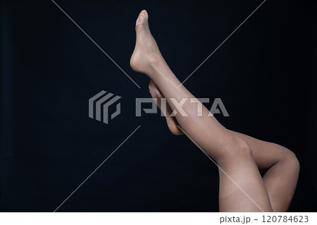 female legs in tights stockings on a black background female legs in tights stockings on a black background 120784623