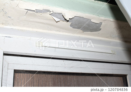 Peeling Damaged Flaking and Falling Down Paint on a Ceiling in a Damp Bathroom 120784836
