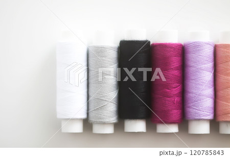 Many colorful sewing threads on light background. 120785843