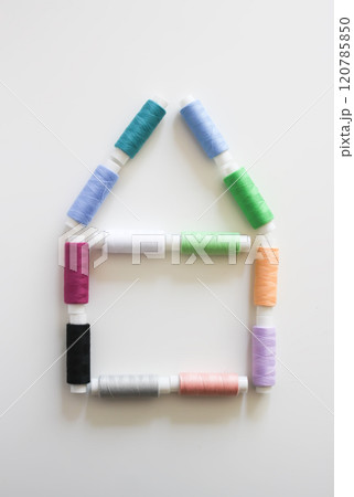 Many colorful house-shaped sewing threads on light background. 120785850