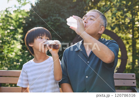 飲み物を一緒に楽しむ孫と祖父 飲み物を一緒に楽しむ孫と祖父 120786316