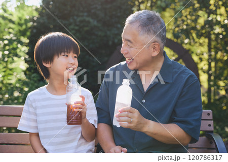 飲み物を一緒に楽しむ孫と祖父 飲み物を一緒に楽しむ孫と祖父 120786317