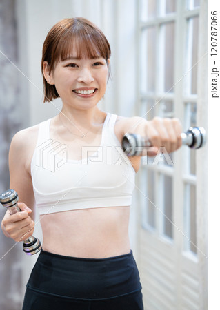ダンベルでトレーニングする若い女性 120787066