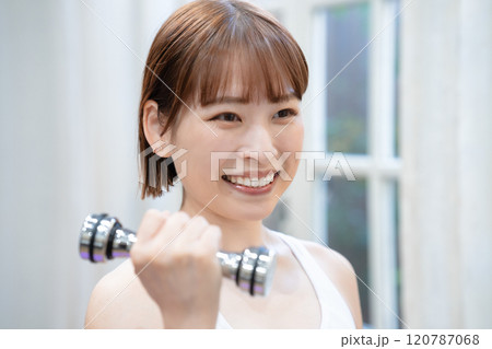 ダンベルでトレーニングする若い女性 120787068