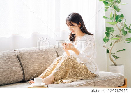 ソファに座ってスマホを見る女性 120787455