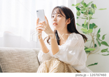 ソファに座ってスマホを見る女性 ソファに座ってスマホを見る女性 120787460