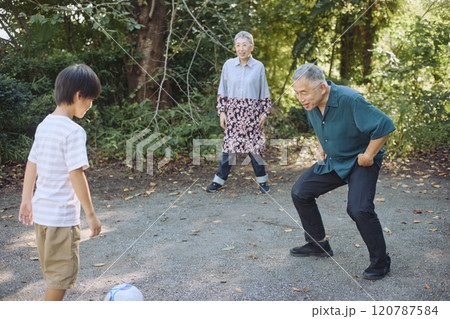 サッカーをするシニアの夫婦と孫 120787584
