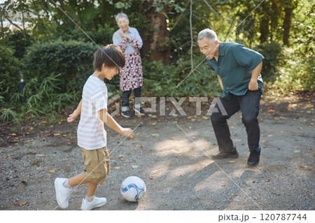 サッカーをするシニアの夫婦と孫 120787744