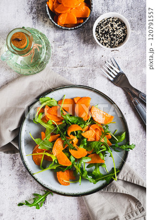 Vegetarian salad with sweet potato and arugula on a plate on the table top and vertical view 120791557