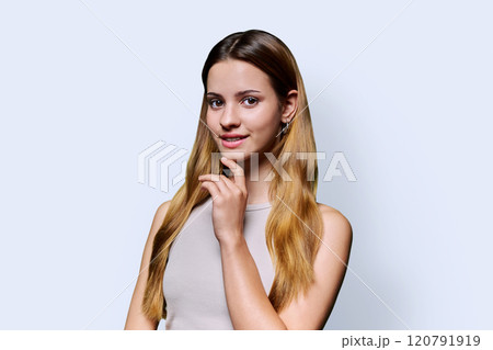 Portrait of beautiful young girl with long red hair looking at camera on white background 120791919
