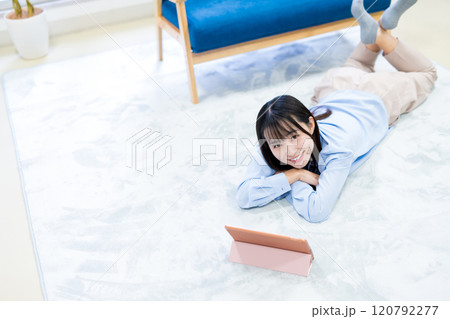 タブレットでYouTube動画を寝転んで見る若い女性　休日　リラックス　動画視聴 120792277