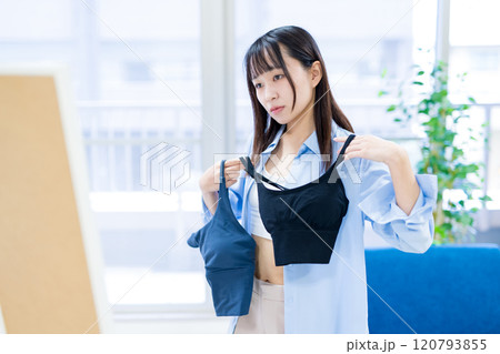 姿見鏡の前で洋服と下着を選ぶ若い女性　スポーツブラ　下着選び　 120793855