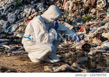 Sanitation worker at the landfill. Landfill with household waste. Environment pollution Sanitation worker at the landfill. Landfill with household waste. Environment pollution 120794750