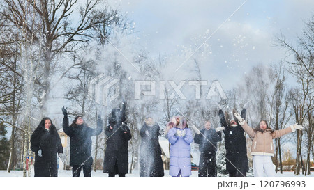 Schoolgirls having a blast throwing snow in the air and enjoying winter in the park 120796993