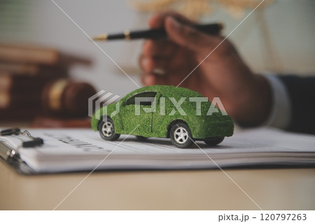 Judge gavel and miniature car symbolize auction or court case against driver who has accident and receiving vehicle insurance payment be on table in front of hands of lawyers. Selective focus Judge gavel and miniature car symbolize auction or court case against driver who has accident and receiving vehicle insurance payment be on table in front of hands of lawyers. Selective focus 120797263