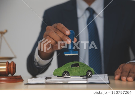Judge gavel and miniature car symbolize auction or court case against driver who has accident and receiving vehicle insurance payment be on table in front of hands of lawyers. Selective focus 120797264