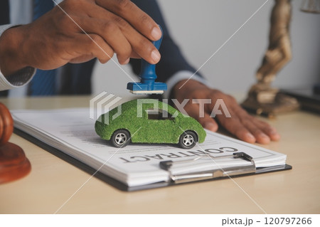 Judge gavel and miniature car symbolize auction or court case against driver who has accident and receiving vehicle insurance payment be on table in front of hands of lawyers. Selective focus Judge gavel and miniature car symbolize auction or court case against driver who has accident and receiving vehicle insurance payment be on table in front of hands of lawyers. Selective focus 120797266