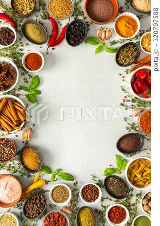 A lively frame of assorted herbs and spices on gray, highlighting the vibrant colors and flavors for cooking inspiration, top view and copy space 120797508