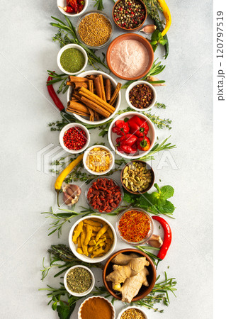 A beautiful display of cooking spices and dried herbs on a gray background, offering a palette of natural hues ideal for culinary inspiration 120797519