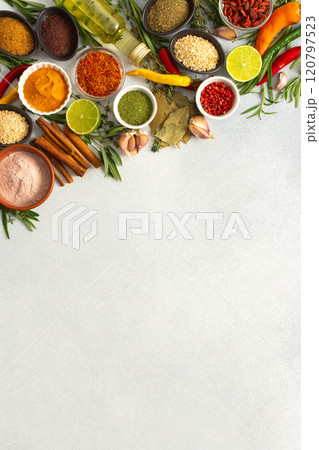 Colorful herbs and spices scattered across a gray surface, ideal for creating authentic and flavorful dishes, top view and copy space 120797523