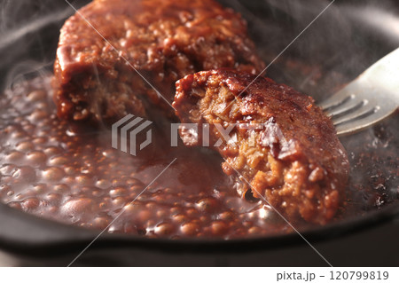 鉄板の上で焼く熱々の湯気の上がるジューシーなハンバーグステーキ 鉄板の上で焼く熱々の湯気の上がるジューシーなハンバーグステーキ 120799819