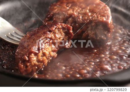 鉄板の上で焼く熱々の湯気の上がるジューシーなハンバーグステーキ 鉄板の上で焼く熱々の湯気の上がるジューシーなハンバーグステーキ 120799820
