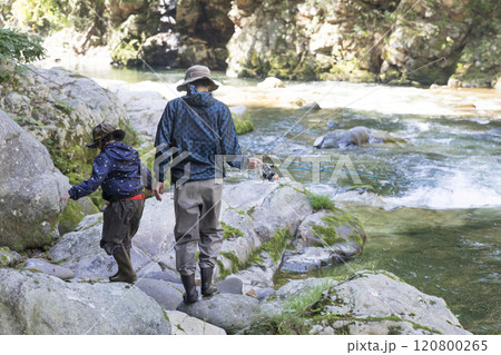 渓流釣りでポイントまで移動する親子 120800265
