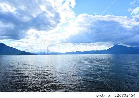 【北海道】雲の間から日差しが差し込む支笏湖 120802454