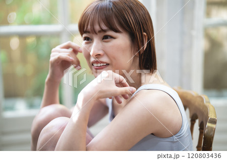 窓際でくつろぐショートボブの若い女性 窓際でくつろぐショートボブの若い女性 120803436