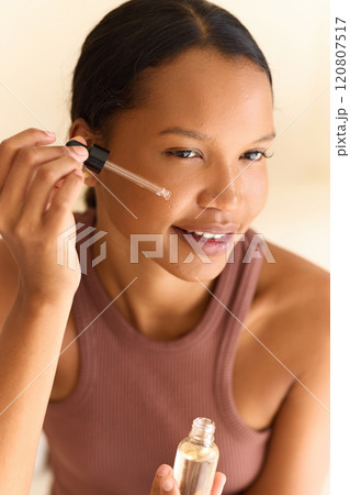 Woman Applying Face Serum for Glowing and Radiant Skin Care Routine 120807517