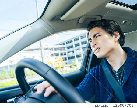 イライラしながら自動車を運転する男性ドライバー イライラしながら自動車を運転する男性ドライバー 120807703
