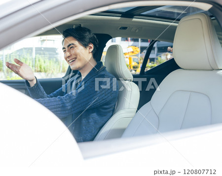 笑顔で道を譲る男性ドライバー 120807712