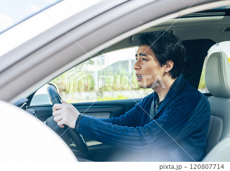 イライラしながら自動車を運転する男性ドライバー イライラしながら自動車を運転する男性ドライバー 120807714