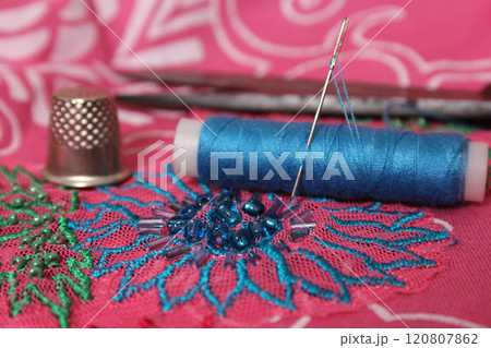 Spool of Blue Thread on Vintage Beaded Fabric Spool of Blue Thread on Vintage Beaded Fabric 120807862